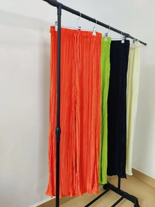 Detailed view of elastic drawstring waist and pleated texture on wide-leg trousers