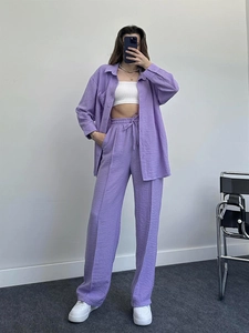 Close-up of textured purple long-sleeve shirt and matching high-waisted wide-leg trousers