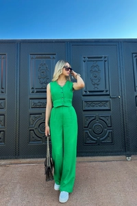 Detail view of vibrant green two-piece set featuring button-up vest and wide-leg trousers