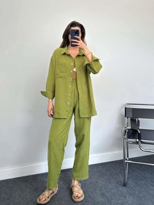 Detail view of olive green textured cotton linen shirt and wide leg pants set fabric