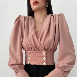 Elegant V-neck puff sleeve blouse in dusty rose with decorative gold buttons and slim waist