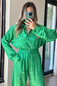 Detail of neon green leopard print two-piece satin set with shirt and wide-leg trousers