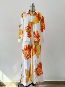 Detail of floral print shirt and wide-leg trousers set with orange hibiscus pattern