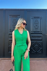Detail of green sleeveless vest featuring a V-neck and decorative flaps in a linen texture