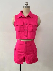 Detail view of fuchsia two-piece set featuring sleeveless crop shirt and high-waist shorts