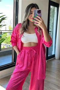 Detail of rose pink satin set showing leopard jacquard texture and relaxed fit shirt