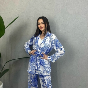 Detail view of women's long sleeve suit featuring blue floral print and waist tie design