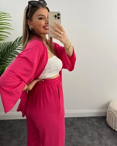 Dettaglio ravvicinato del set due pezzi fucsia in tessuto testurizzato con tasche