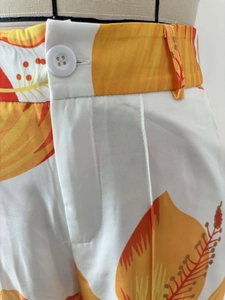 Detail view of floral print high waist trousers with white buttons and zip fly closure