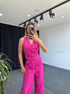 Detail of fuchsia V-neck sleeveless vest and high-waisted wide-leg trousers set
