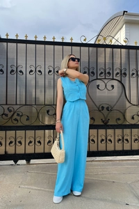 Detail of bright blue textured fabric on a sleeveless cropped vest and wide leg pants set