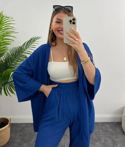 Dettaglio di un set a due pezzi blu navy con trama plissettata e cardigan stile kimono