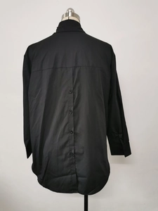 Detail of the unique back button placket on this loose black long sleeve shirt for women