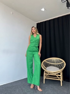 Detail of a bright green sleeveless vest and matching wide-leg trousers on model