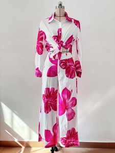 Detail of tropical fuchsia floral print on white long-sleeve shirt and wide-leg trousers