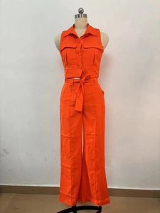 Détail d'un ensemble orange avec chemise sans manches et pantalon large à taille haute