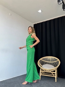 Detailed view of women's two-piece set featuring green sleeveless vest and wide-leg trousers