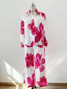 Detailed view of the pink hibiscus floral print on a white long sleeve shirt and pants set