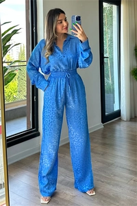 Detail of blue satin leopard jacquard fabric on long sleeve shirt and wide leg trousers