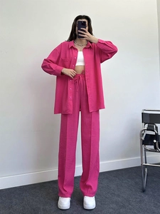 Detail of rose red casual suit showing the loose long-sleeved shirt and drawstring trousers