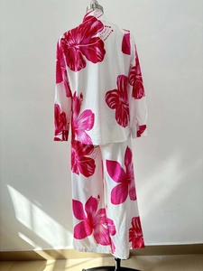 Detail of pink floral print on white two-piece long sleeve shirt and trousers set
