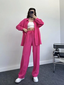 Detail of rose pink textured two-piece set featuring drop shoulder shirt and wide leg pants