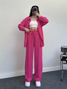 Detail of hot pink loose two-piece set featuring textured fabric and drawstring wide-leg pants