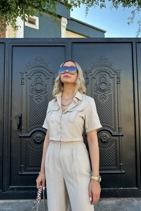 Détail d'un ensemble beige en lin avec chemise à manches courtes et pantalon large