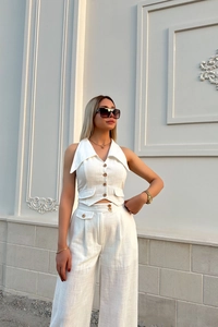 Detail of white linen vest buttons and fabric texture on a two-piece women's set