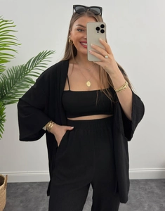 Dettaglio del set 3 pezzi in maglia a coste nera con cardigan, crop top e pantaloni larghi