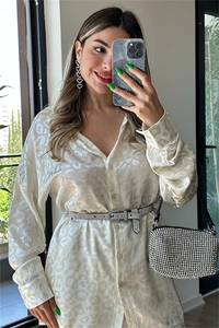 Close-up of champagne leopard jacquard shirt with rhinestone belt and silver handbag