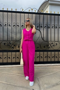 Detail of rose red high-waisted wide-leg trousers and buttoned sleeveless vest set