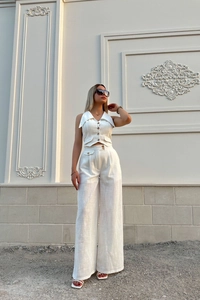 Detailed close-up of textured beige cotton-linen sleeveless vest and high-waist trousers
