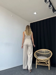 Rear view of beige sleeveless top and high-waisted wide-leg trousers set in minimalist style