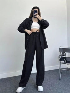 Minimalist black lounge set with long-sleeved shirt and wide-leg trousers detail