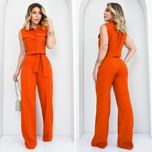 Détail d'un ensemble deux pièces orange vif avec haut sans manches et pantalon large fluide