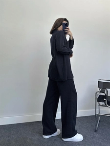 Detail view of black long sleeve shirt and wide leg pants set with loose fit texture