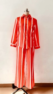 Dettaglio del set camicia a maniche lunghe a righe rosse e bianche e pantaloni larghi
