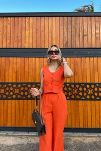 Detail of vibrant orange summer set featuring a V-neck cropped vest and high-waisted trousers