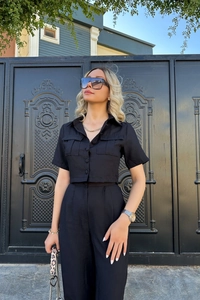 Détail d'un ensemble chic noir deux pièces avec chemise à manches courtes et pantalon large