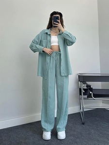 Close-up of sage green textured fabric on loose-fit long sleeve shirt and trousers set