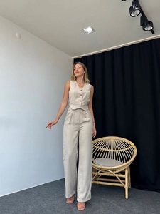 Detail of V-neck single-breasted vest and high-waist wide-leg trousers in linen fabric