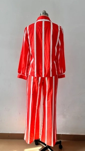 Vista posteriore del set due pezzi in raso a righe rosse e bianche con camicia e pantaloni
