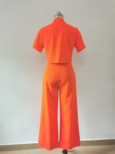 Rear view of vibrant orange women's two-piece set featuring cropped top and wide-leg pants