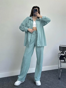 Detail of mint green linen shirt and wide-leg trousers set with drawstring waist