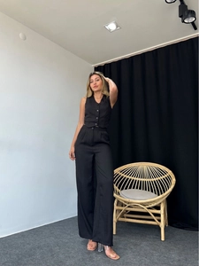 Detail of a chic black two-piece set featuring a V-neck vest and wide-leg trousers