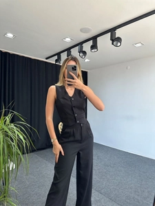 Detail shot of a black sleeveless vest and high-waisted wide-leg trousers suit set
