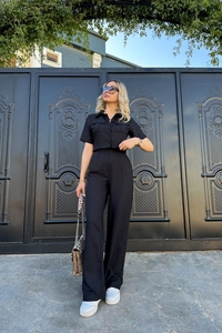 Détail de l'ensemble noir deux pièces avec haut à revers et pantalon large à taille haute