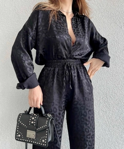 Detail of black leopard print satin shirt and drawstring trousers with studded handbag