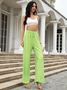 Detailed macro view of the pleated fabric texture on lime green wide leg pants